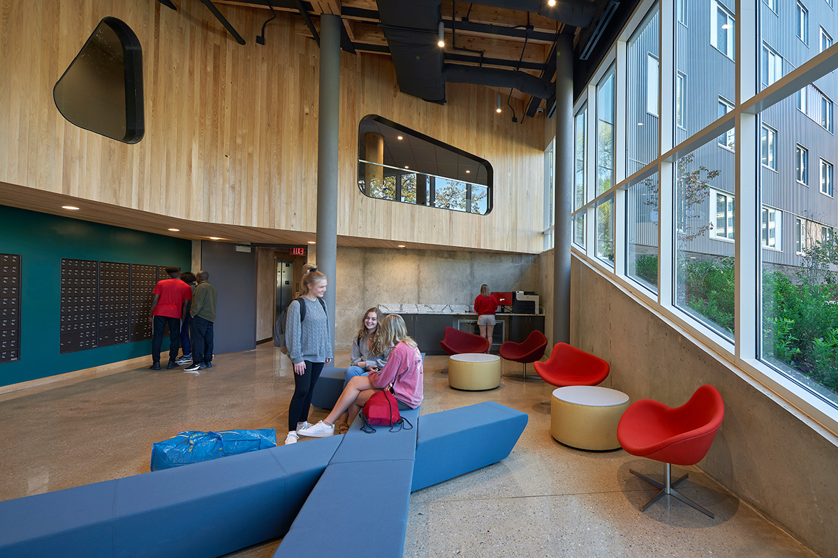 młody uczeń czytający książkę pod drzewem na przerwie z nogami skrzyżowanymi