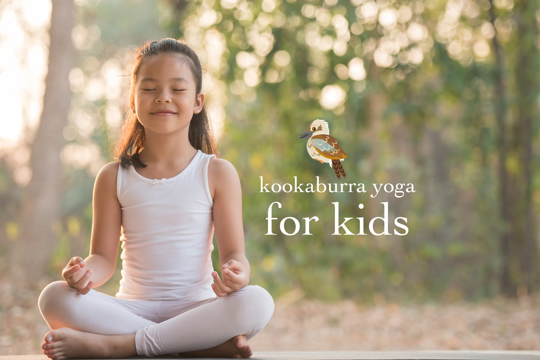 uśmiechnięte dzieci zwijają maty jogowe po sesji w szkolnej sali gimnastycznej