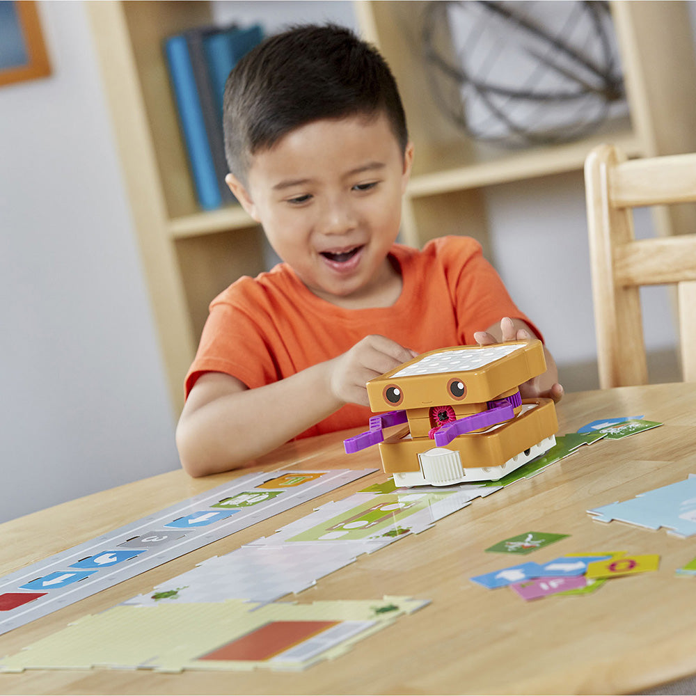 grupa dzieci gra w edukacyjną grę kodowania na dużym tablecie dotykowym