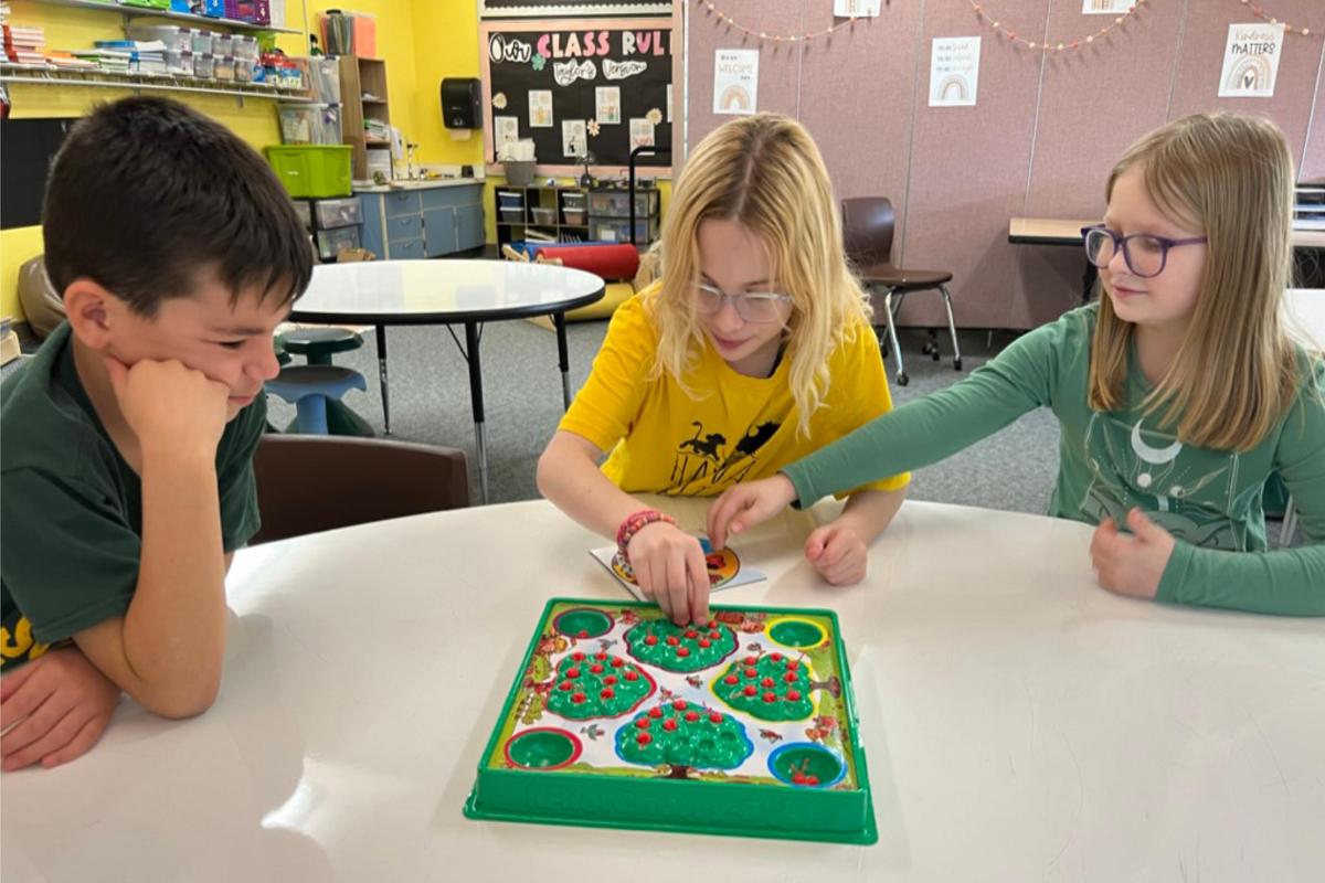 nauczycielka rozdaje karty z zadaniami matematycznymi