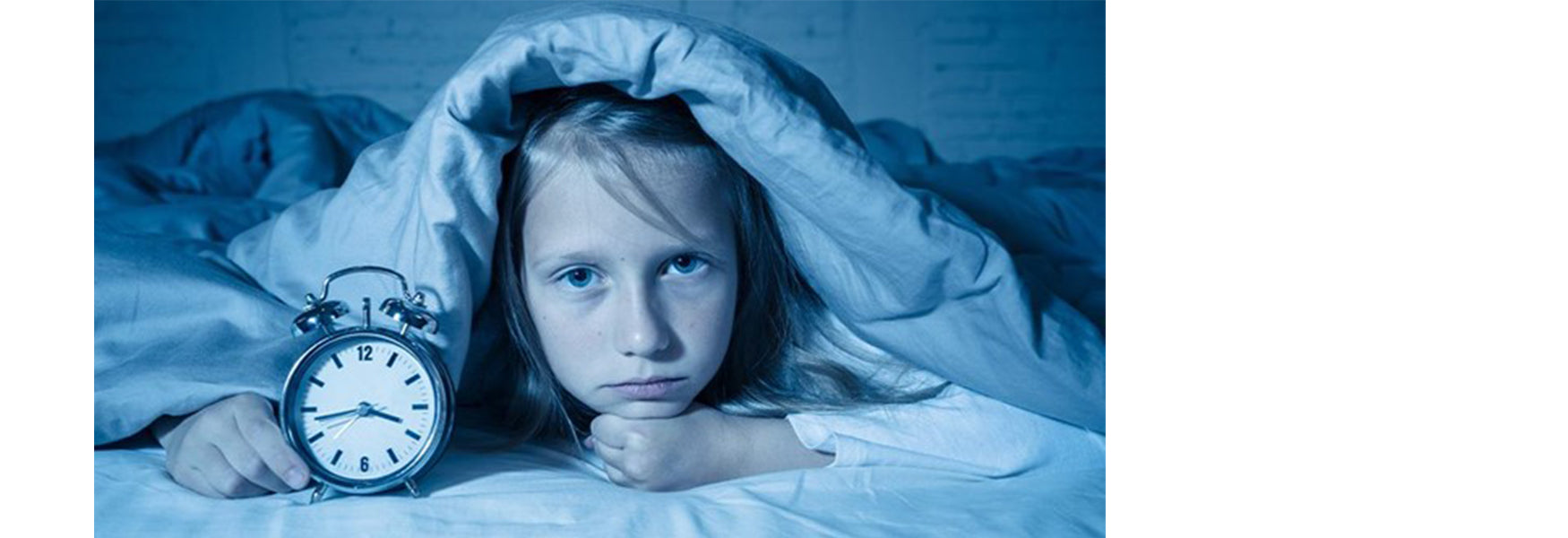 kolorowy budzik w kształcie pluszowego misia na szafce nocnej dziecka