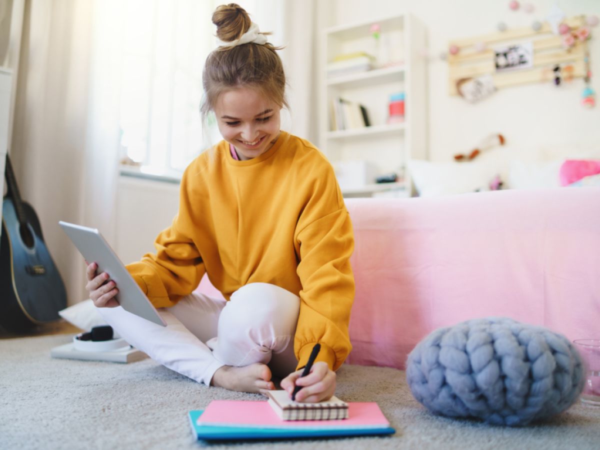 dziecko szkolne rysujące przy biurku z napiętą miną i zmarszczonym czołem