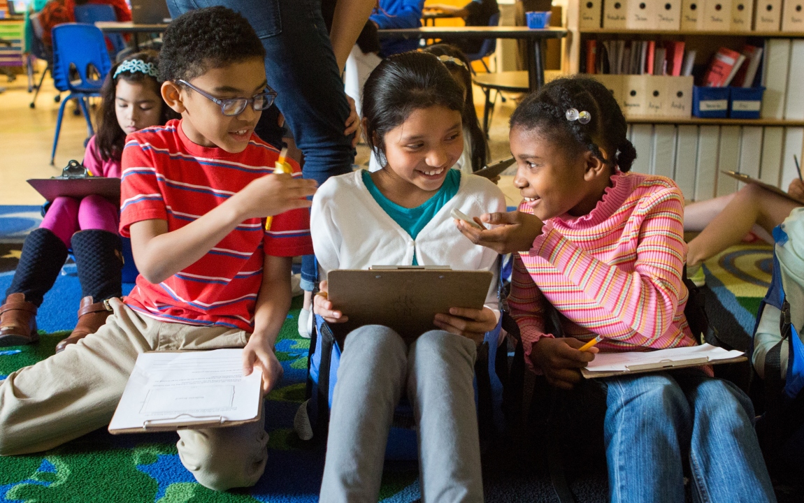 uczniowie na szkolnym podwórku mierzą rośliny do projektu ekologicznego
