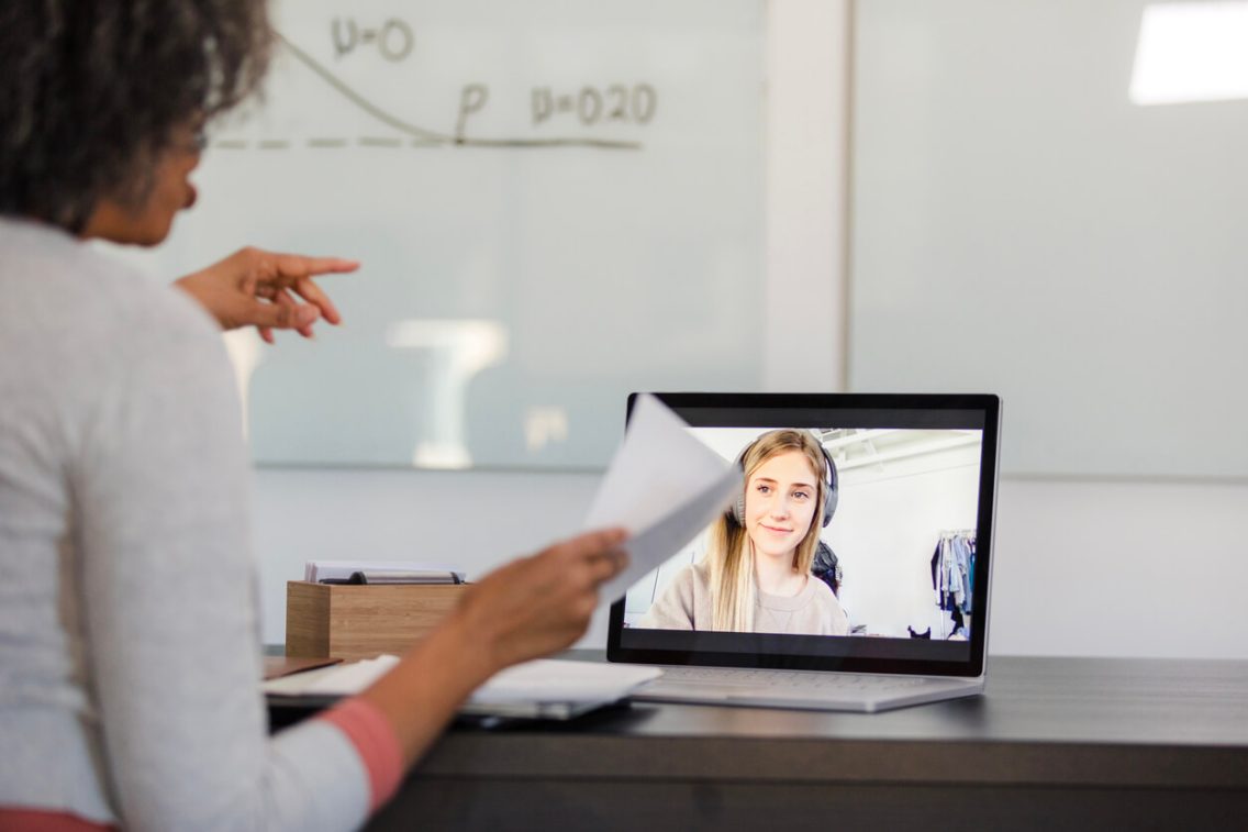 rodzice z synem siedzą przed laptopem podczas rozmowy z pedagogiem na ekranie