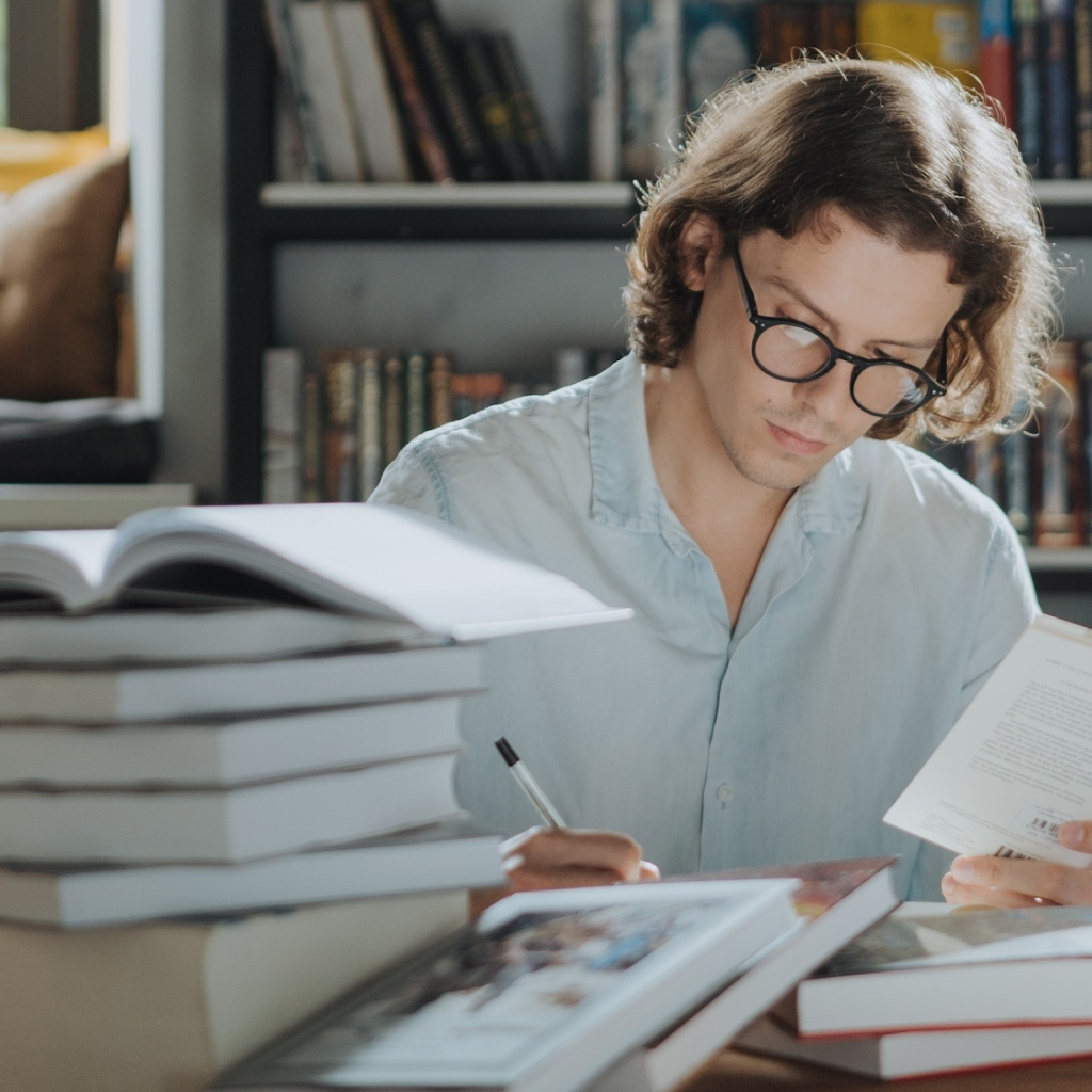 chłopiec zakrywa dłonią usta czytając książkę by uniknąć wymawiania