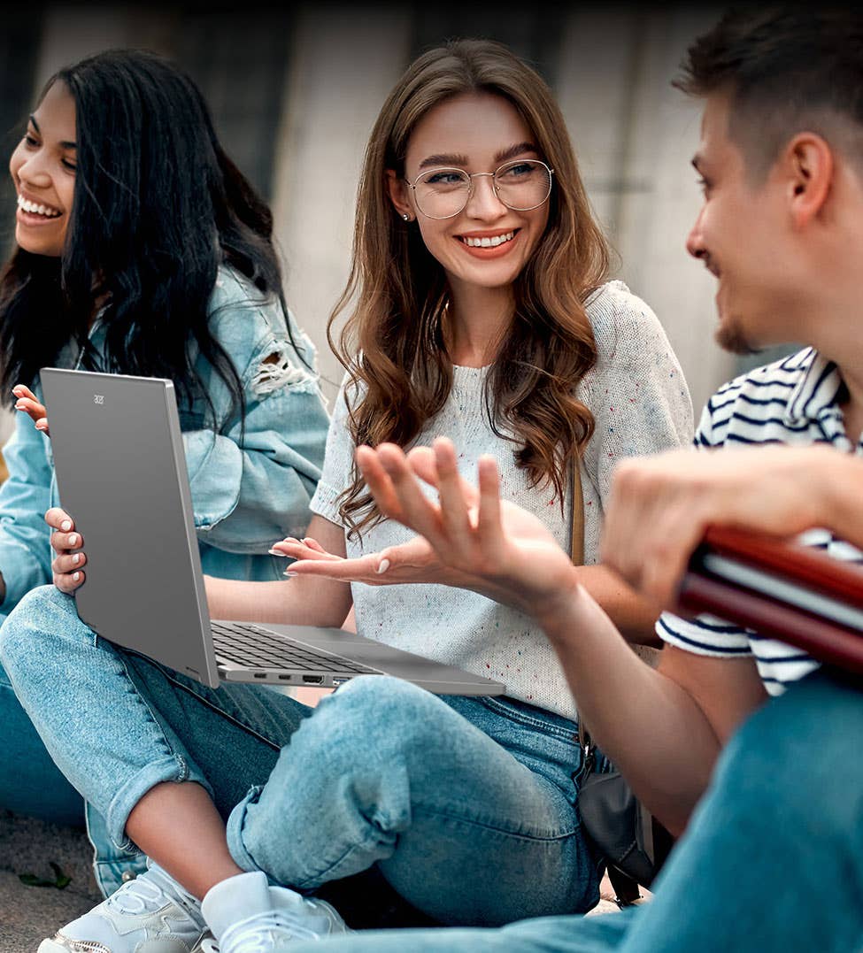 uczeń podłączający pendrive do bocznego portu USB w cienkim laptopie aluminiowej obudowy