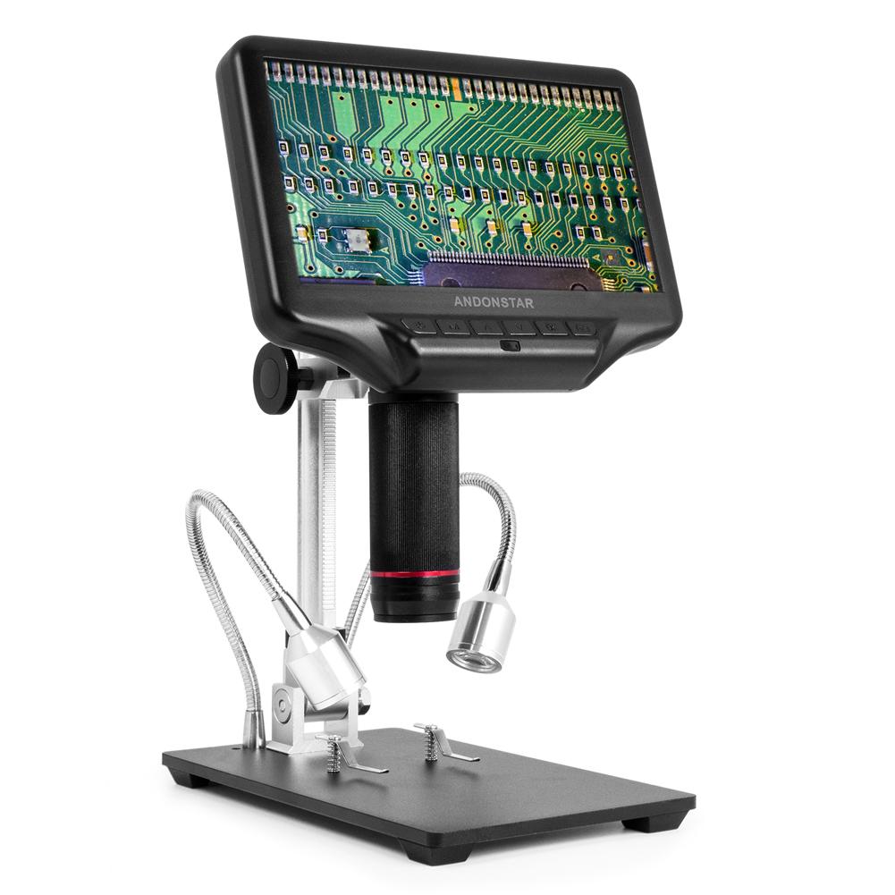 dziecko obraca pokrętło ostrości mikroskopu USB przy próbce piasku