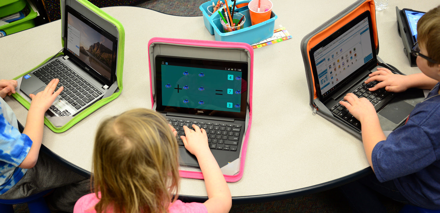 uczeń szkolny pracujący na laptopie przy biurku w jasnym pokoju studyjnym z otwartymi podręcznikami