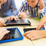 close up of school kids playing with tablet pc