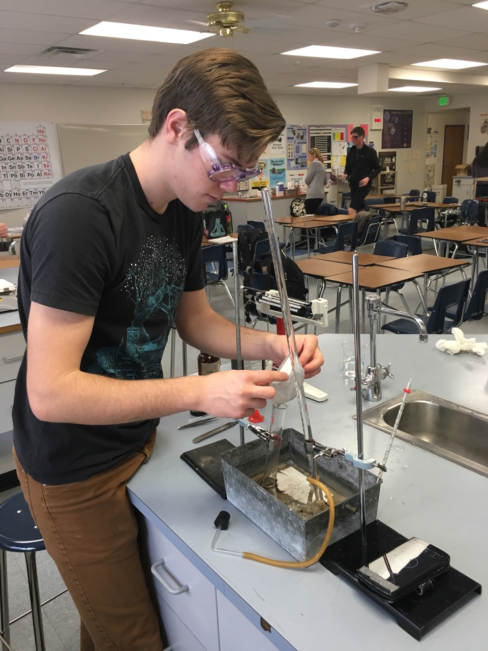 międzynarodowi studenci programu IB międzynarodowa grupa uczniów z flagami krajów na tle logo IB w auli