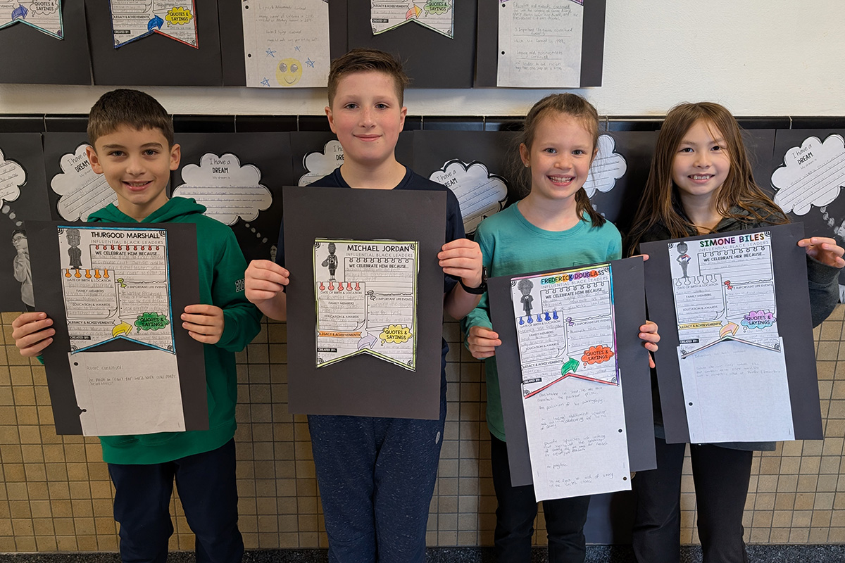 grupa uczniów buduje model wulkanu z papieru i farb na stole