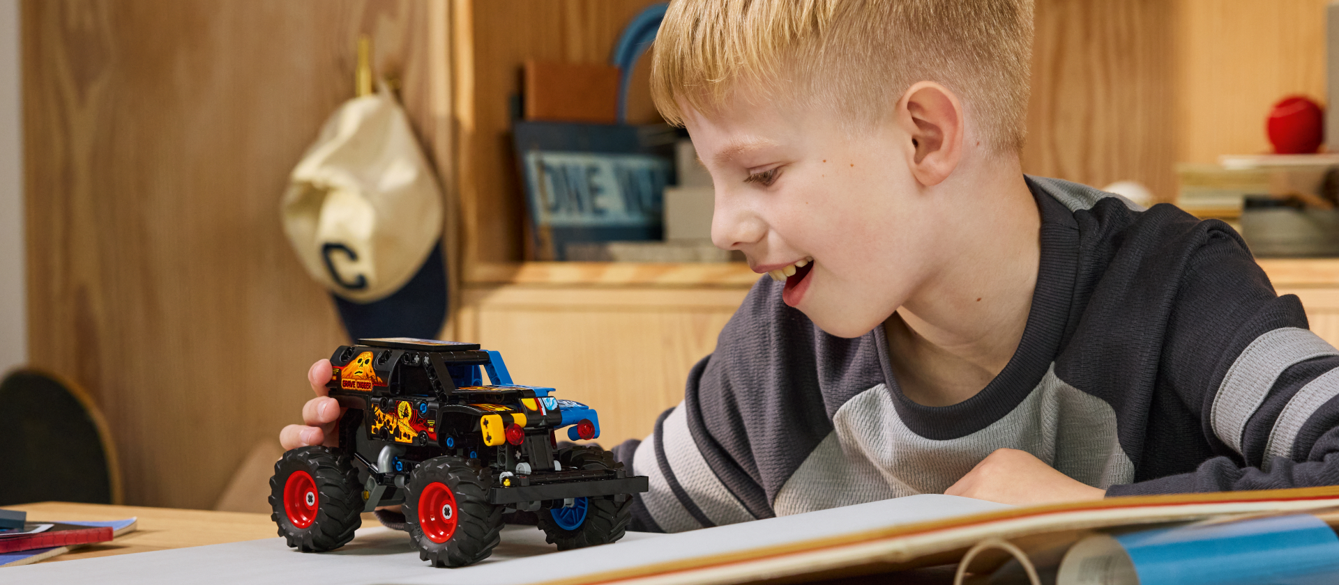 chłopiec z instrukcją obok rozłożonych części lego technic