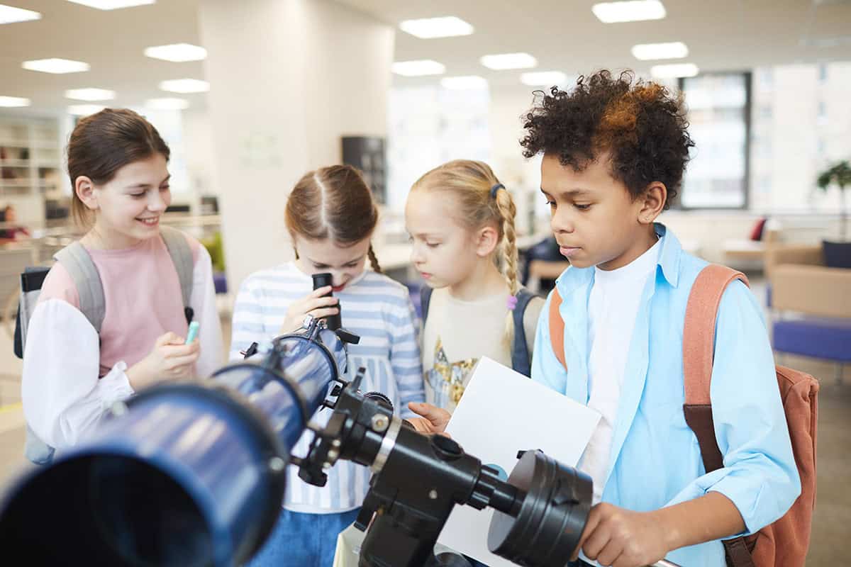 nauka obserwacji kosmosu uczeń szkoły podstawowej ustawiający teleskop na balkonie