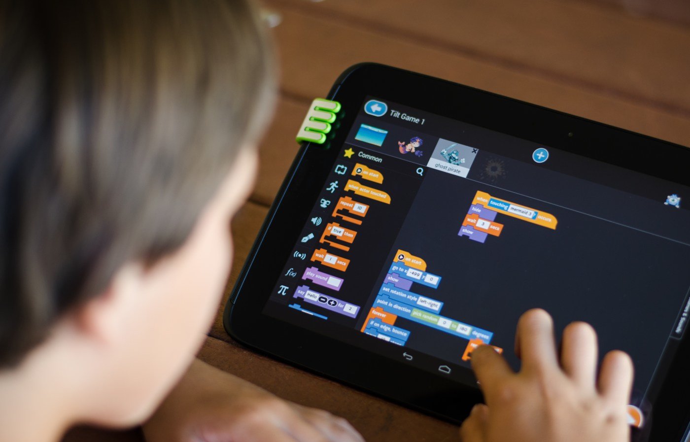 rysowanie w Scratch dla dzieci dziewczynka rysuje animowanego kota w programie Scratch na ekranie tabletu