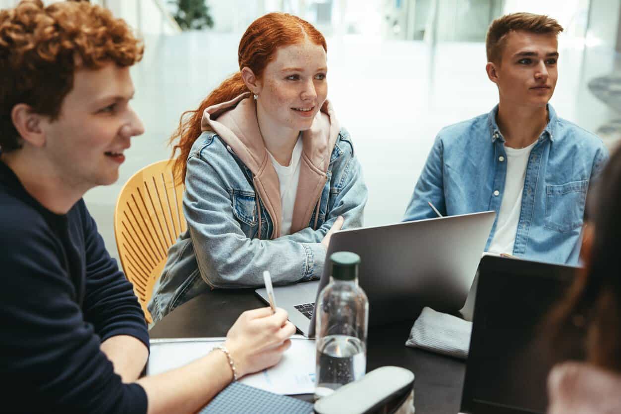 uczniowie wykonujący eksperyment z probówkami na stole